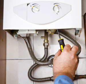 Plumber at work. Servicing gas boiler